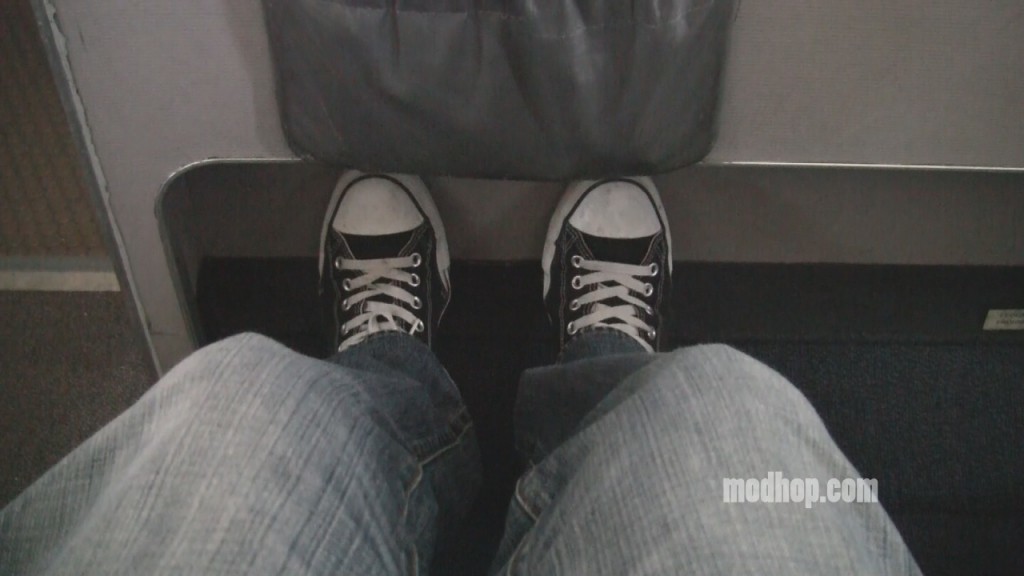 a person's legs and feet in jeans and black sneakers