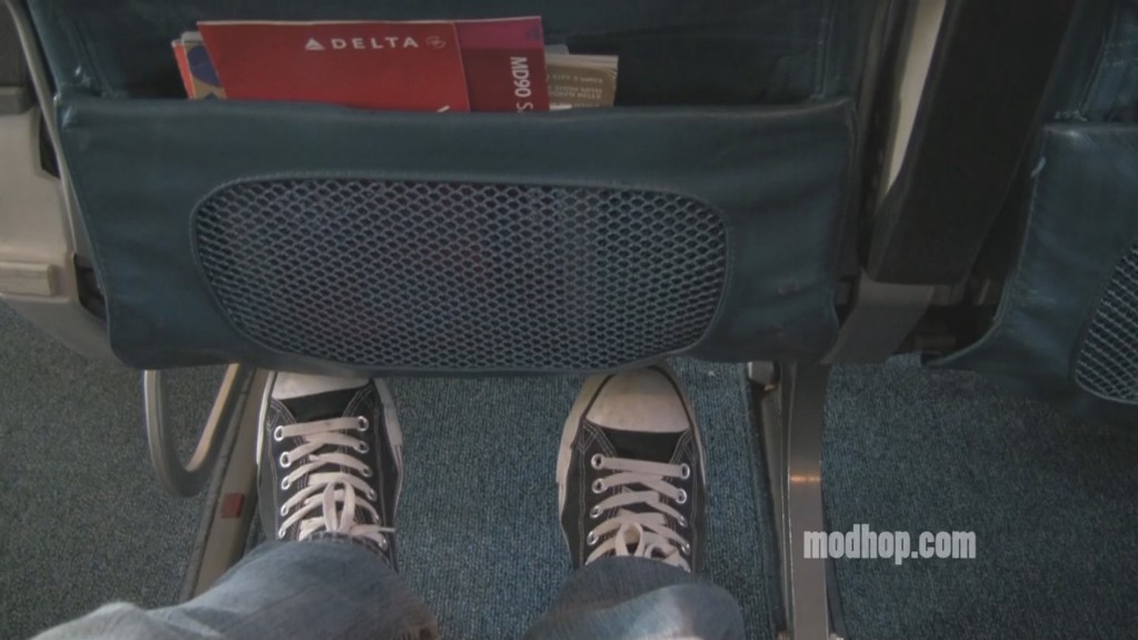 a person's legs and shoes in a seat