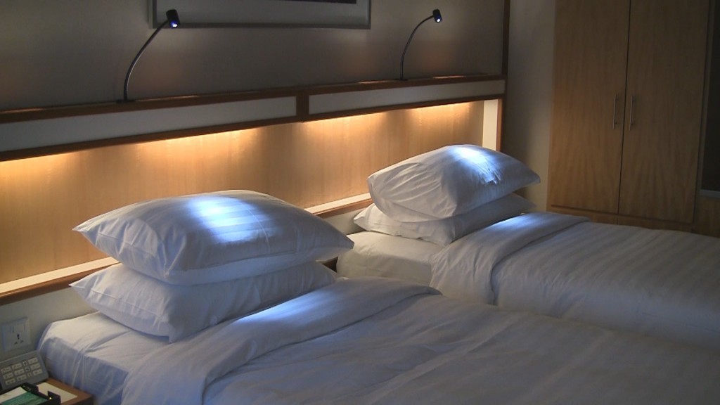 a couple of beds with white pillows