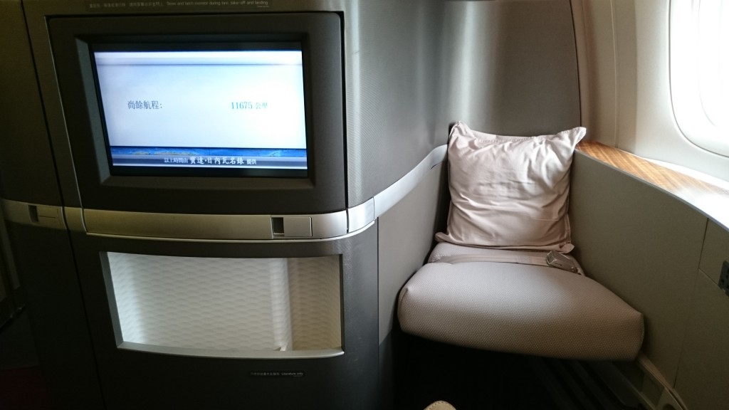 a seat with a white pillow and a screen