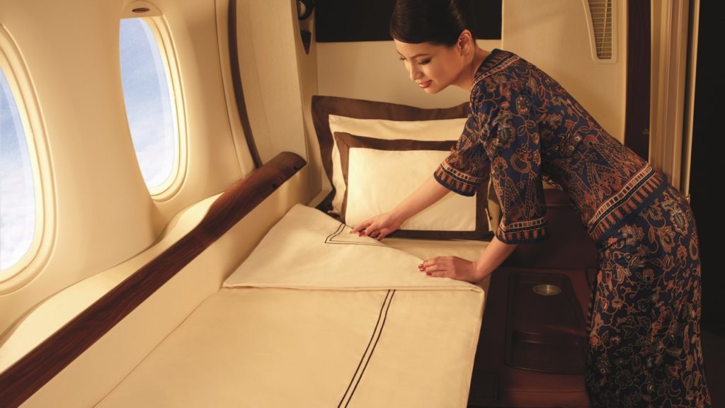 a woman making bed in an airplane