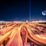 a city at night with the moon