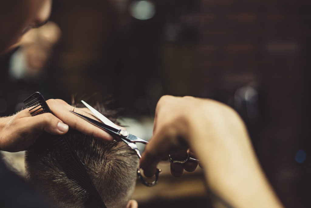 a person cutting hair of a man