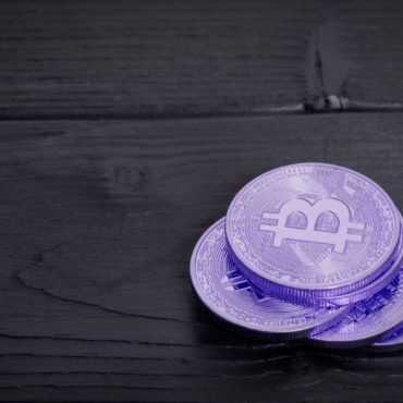 Violet Bitcoins on a table