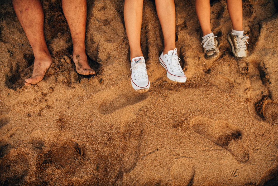 a group of people's feet in the sand