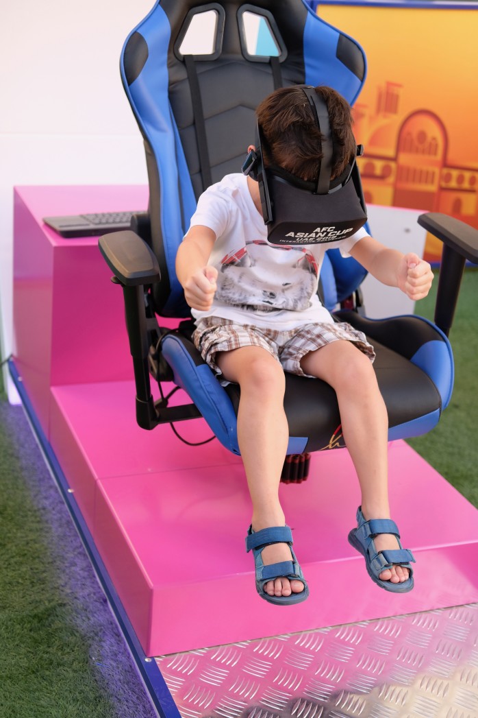 a boy sitting in a chair with a virtual reality headset