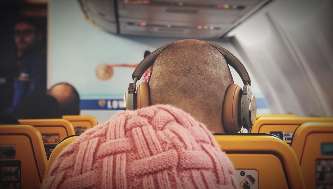 a person wearing headphones sitting on a yellow seat