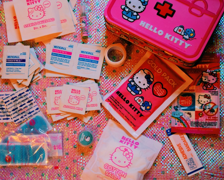 a pink first aid kit with a hello kitty design on it