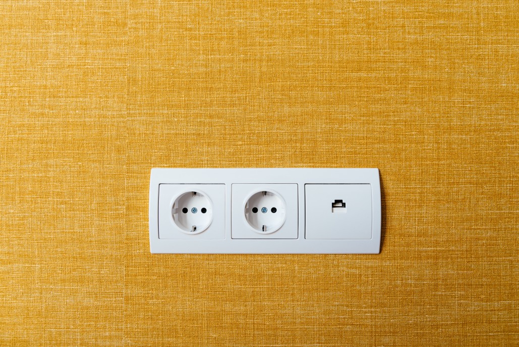 a white electrical outlet on a yellow surface