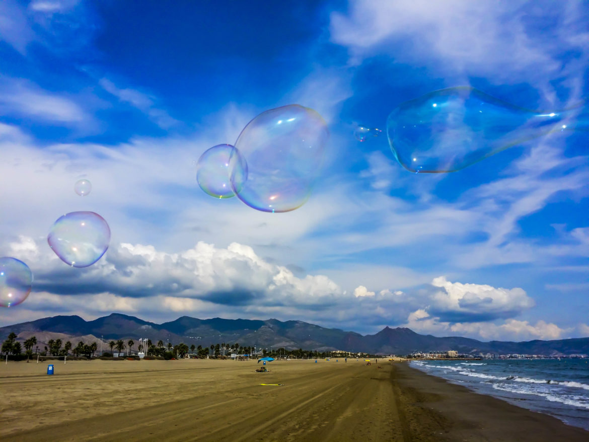 bubbles floating in the air on a beach