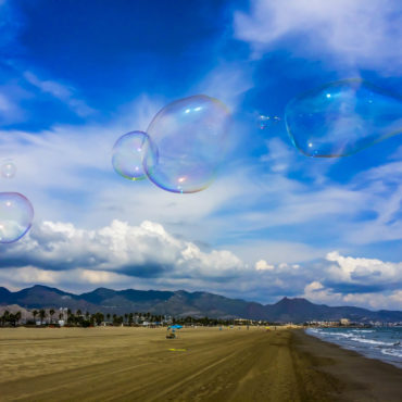 bubbles floating in the air on a beach