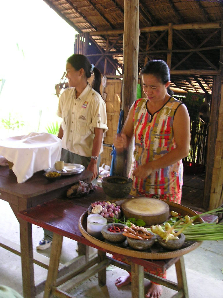 a woman standing next to a table with food