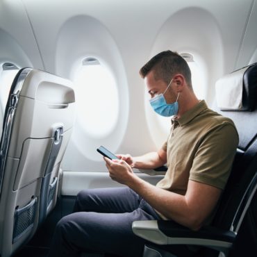 Man wearing face mask inside airplane