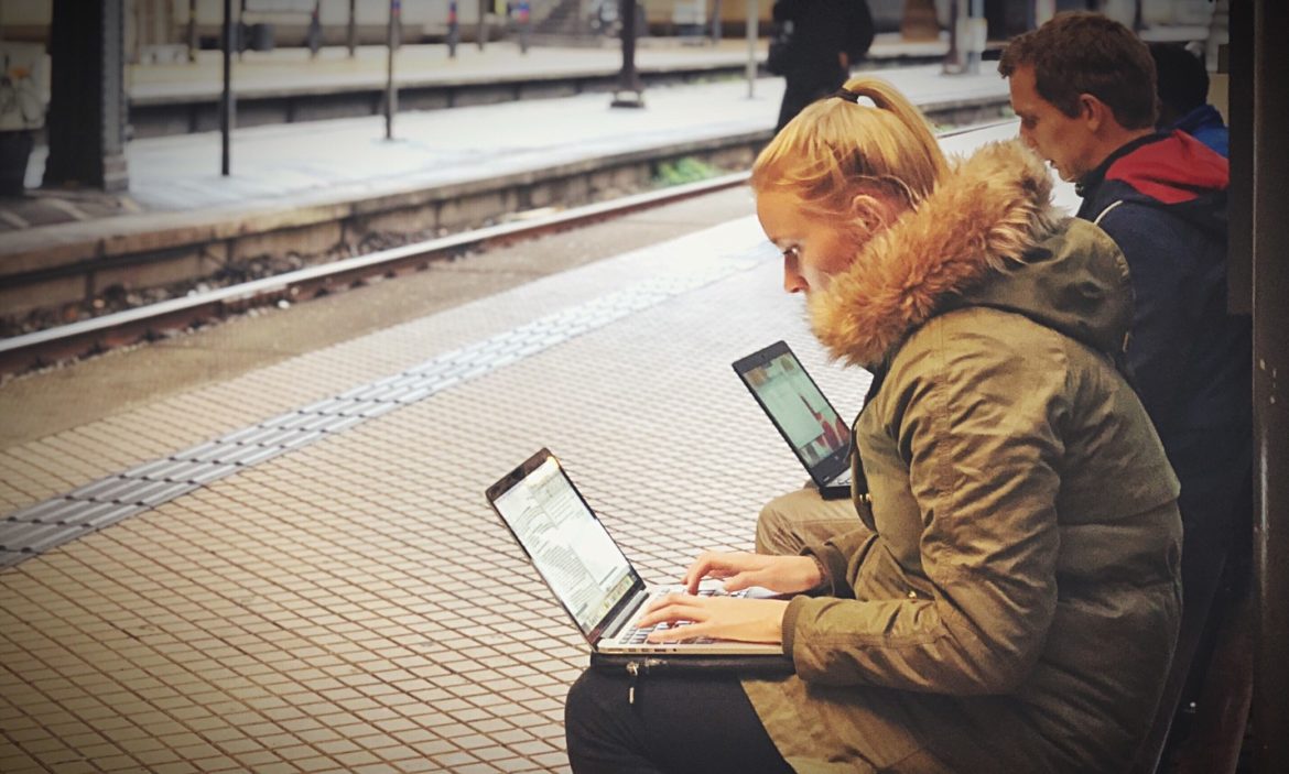 a woman sitting on a platform with laptops