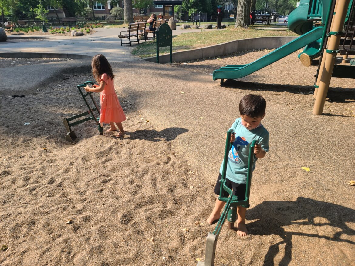 a boy and girl playing in sand