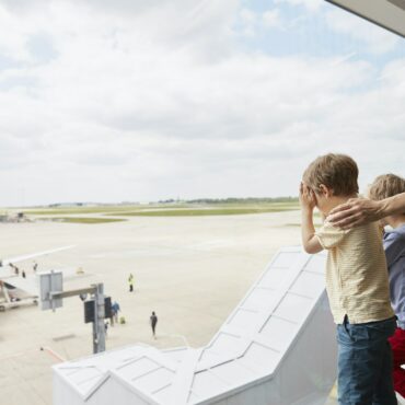 Mother and sons looking out of airport window