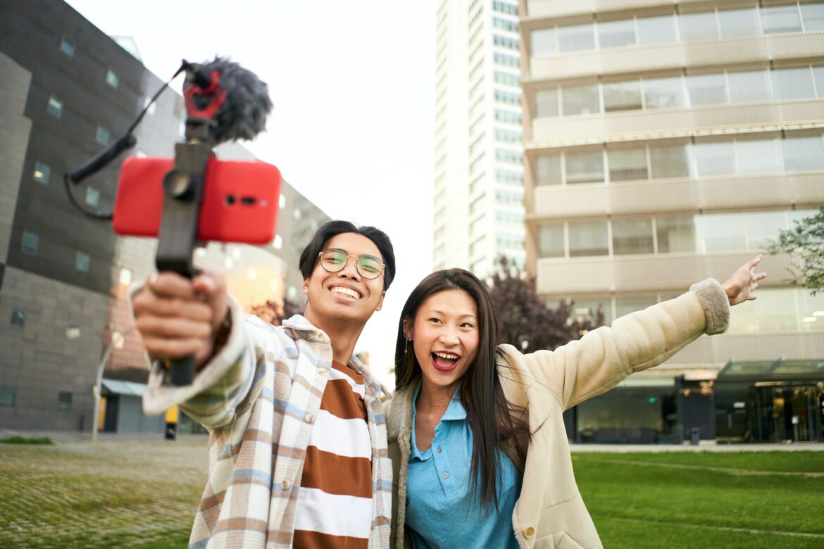 Asian people blogging outdoors. Selfie couple happy travel walk tourists taking photo