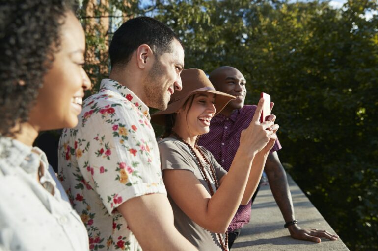 Group Of Tourists Taking Photos On Mobile Phones