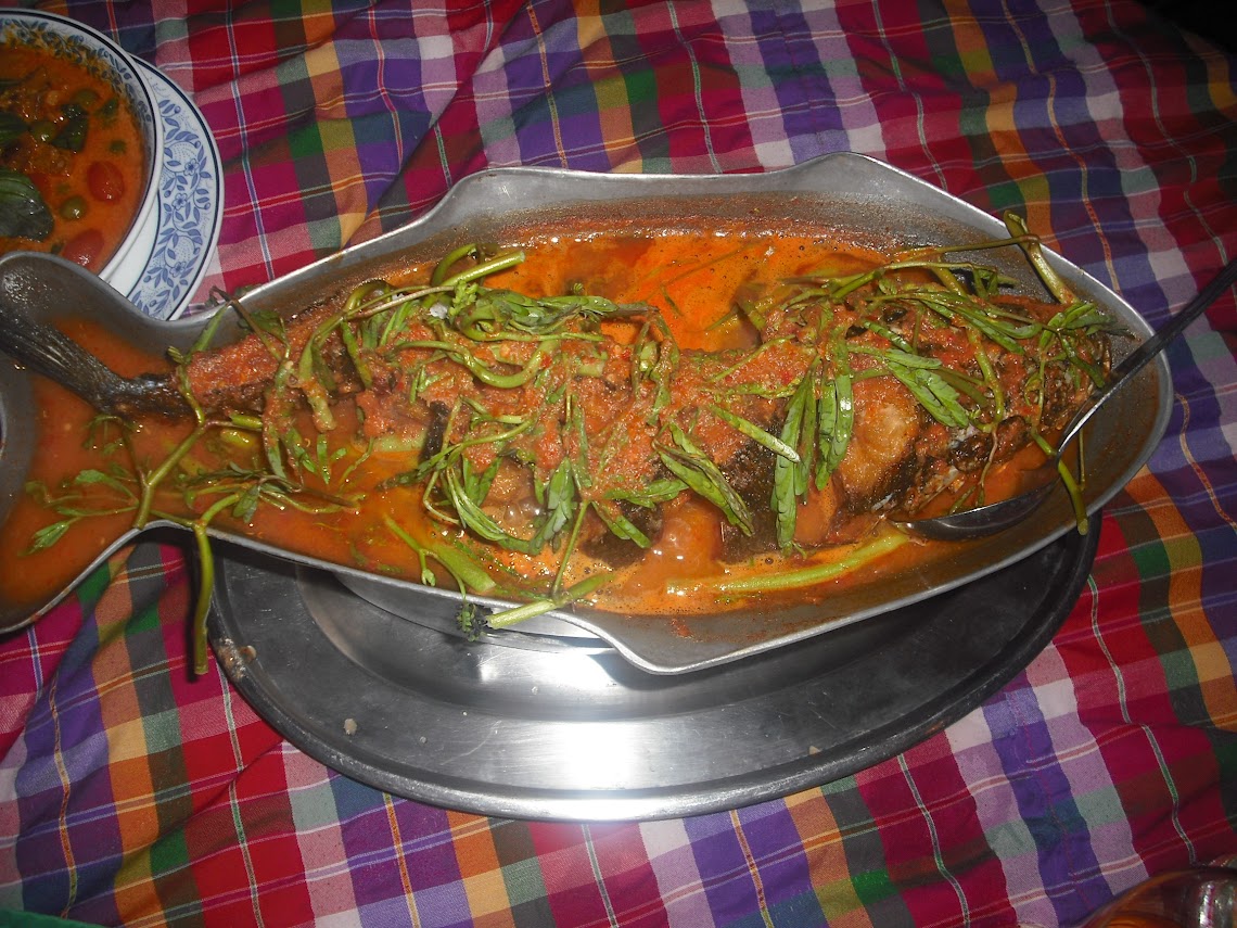 a fish with sauce in a metal container