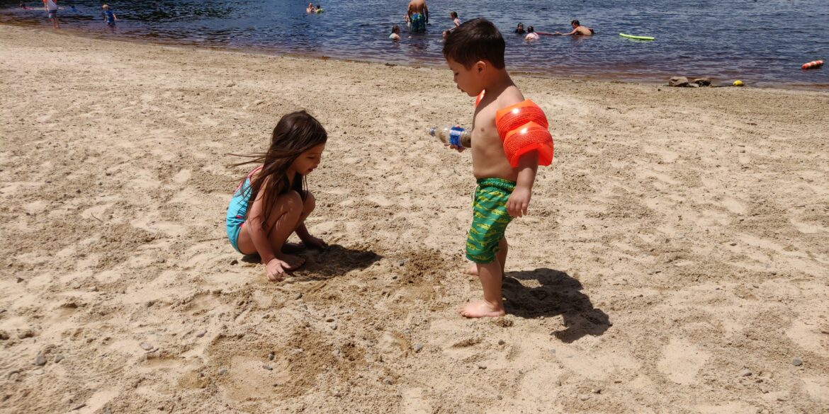 a boy and girl playing on a beach