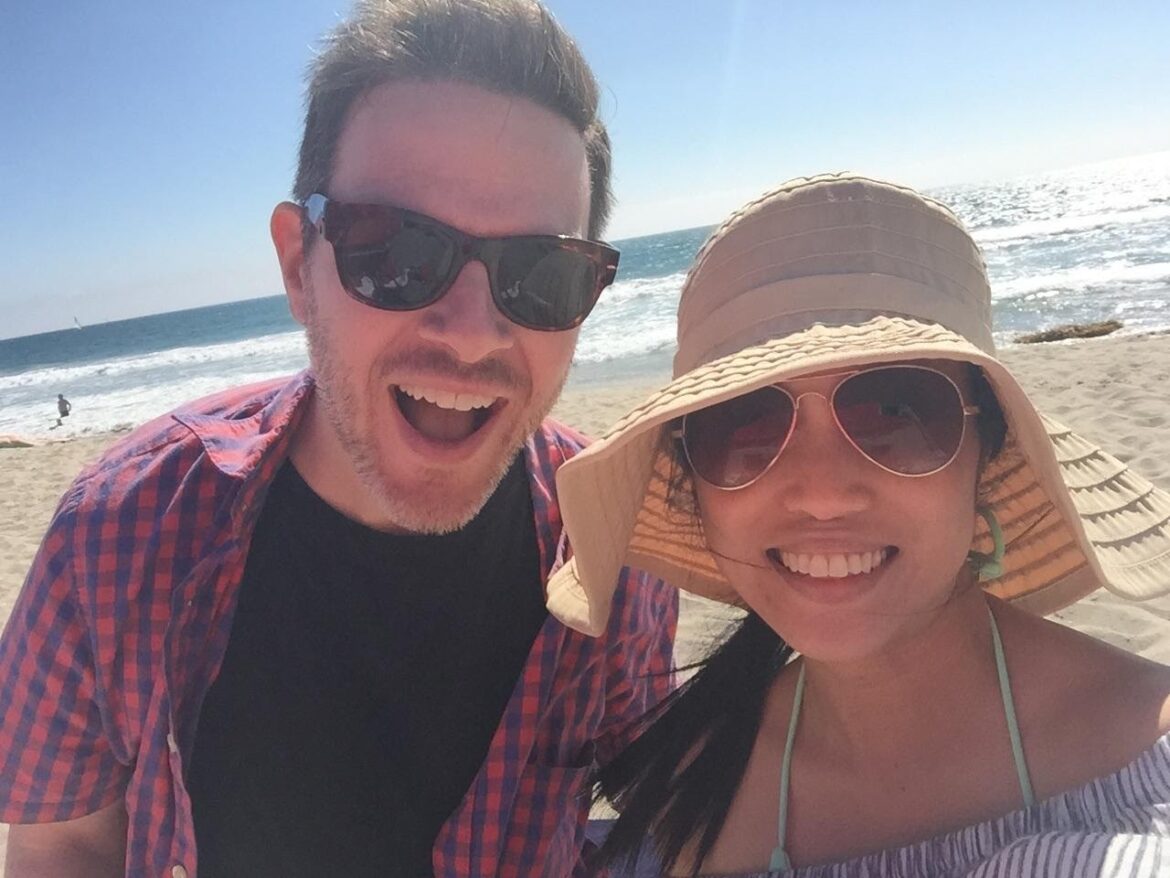 a man and woman taking a selfie at the beach