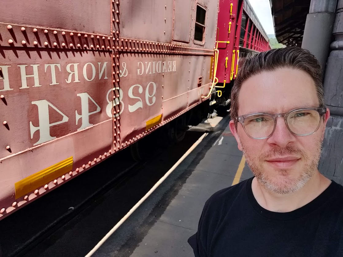 a man taking a selfie in front of a train