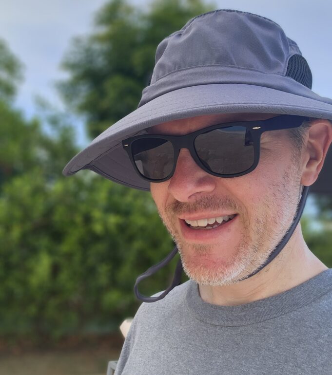 a man wearing a hat and sunglasses