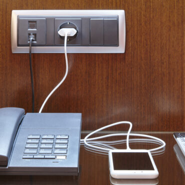 Loading smart phone. Hotel room desk. Travel business background. Equipment