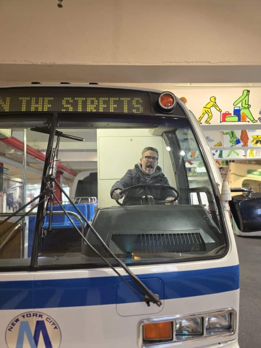 Jake driving a prop bus at the NYC Transit Museum.