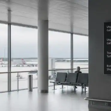 A traveler waiting at a European airport border, showing why EES layover time now means leaving more buffer before a connection.